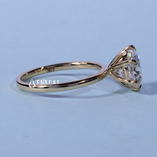 Round Cut Solitaire Moissanite Engagement Ring resting on its side showing the slim band