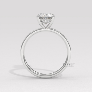 Studio shot of a oval cut moissanite engagement ring with a hidden halo and pave band on a plain backdrop