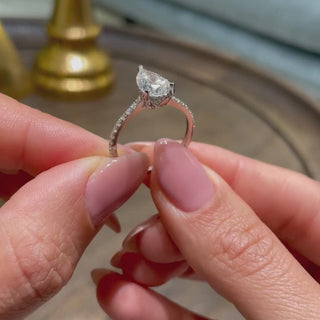 Shimmering 1.5ct pear hidden halo moissanite ring shown on a finger