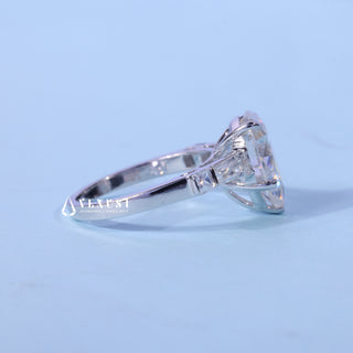 Pear Cut Three Stone Moissanite Ring resting on its side showing the slim band