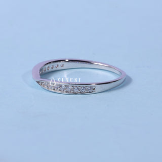 Refined round pave moissanite wedding band shown on a finger