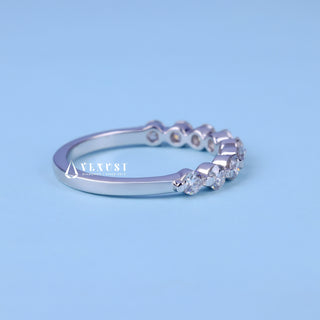 Delicate round half eternity moissanite wedding band close up of the setting