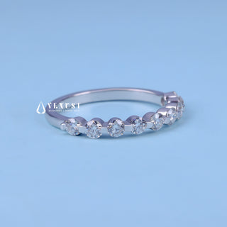Delicate round half eternity moissanite wedding band angled view showing its sparkle