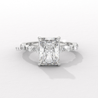Front view of a round cut moissanite engagement ring with a hidden halo and pave band from a high angle