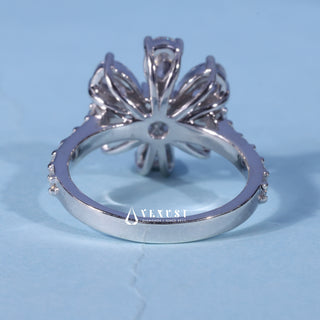 Round Pear Moissanite Flower Cluster Engagement Ring resting on its side showing the slim band