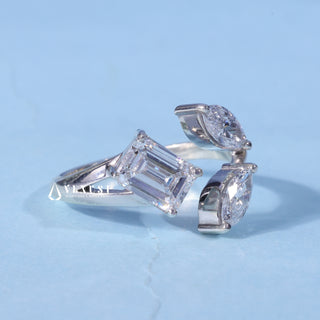 Three Stone Marquise Moissanite Emerald Cut Engagement Ring resting on its side showing the slim band