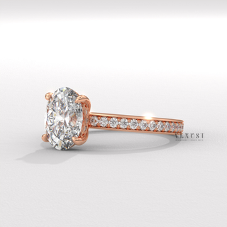 Oval cut moissanite engagement ring with a hidden halo and pave band photographed on a white background
