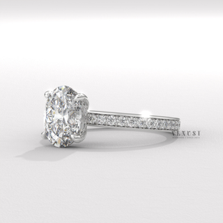 Angled view of a oval cut moissanite engagement ring with a hidden halo and pave band catching the light