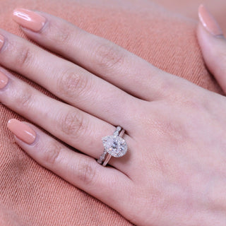 Lustrous 1.50ct pear halo moissanite ring tilted view catching the light