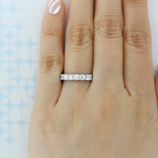 Dazzling round full eternity moissanite wedding band shown on a finger image 2