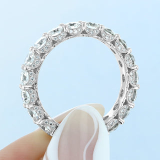 Bold round full eternity moissanite wedding band three quarter angled view
