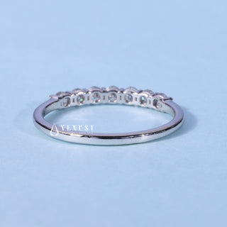 Elegant round half eternity moissanite wedding band shown on a finger