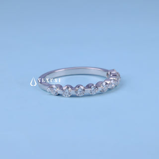 Graceful round pave moissanite wedding band shown on a finger