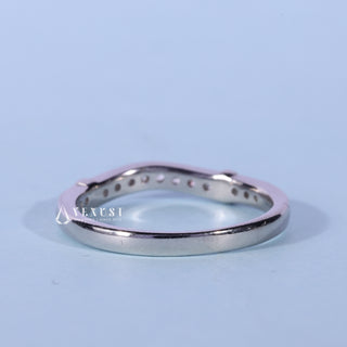 Lustrous round moissanite wedding band shown on a finger
