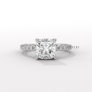 Low-angle view of a cushion cut moissanite engagement ring with a pave band