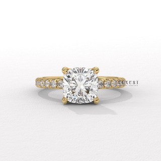 Studio shot of a cushion cut moissanite engagement ring with a pave band on a plain backdrop