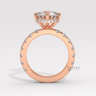Front view of a round cut moissanite engagement ring with a hidden halo and pave band under soft light