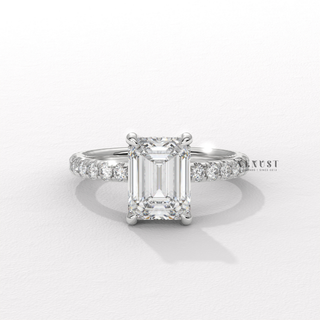 Centre-stone close-up of a emerald cut moissanite engagement ring with a pave band