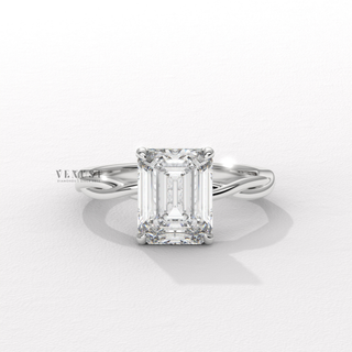 Low-angle view of a emerald cut moissanite engagement ring on an infinity band