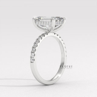 Front view of a emerald cut moissanite engagement ring with a hidden halo and pave band from the left