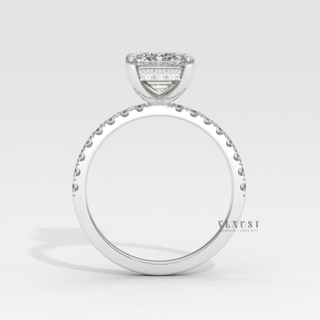 Front view of a emerald cut moissanite engagement ring with a hidden halo and pave band under bright light
