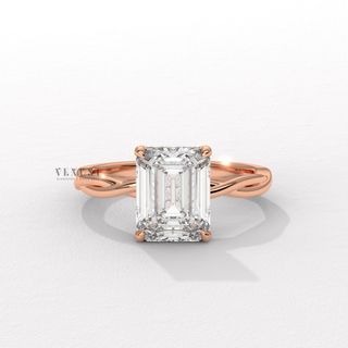 Centre-stone close-up of a emerald cut moissanite engagement ring on an infinity band