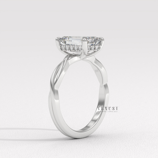 Top-down view of a emerald cut moissanite engagement ring on an infinity band