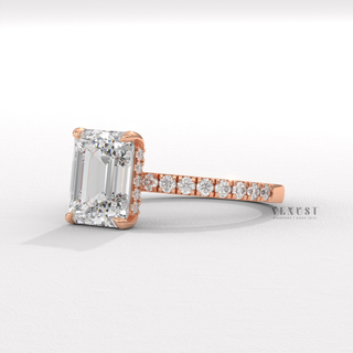 Three-quarter angle of a emerald cut moissanite engagement ring with a hidden halo and pave band