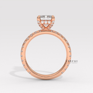 Emerald cut moissanite engagement ring with a pave band shown on a finger