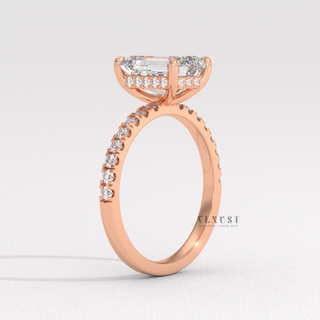 Emerald cut moissanite engagement ring with a hidden halo and pave band photographed on a white background