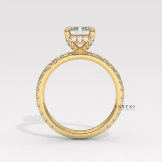 Angled view of a emerald cut moissanite engagement ring with a pave band catching the light