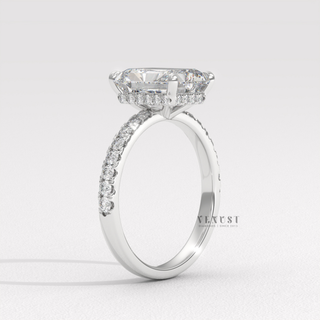 Front view of a radiant cut moissanite engagement ring with a pave band from the left