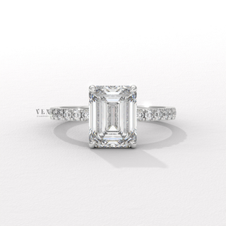 Top-down view of a emerald cut moissanite engagement ring with a hidden halo and pave band