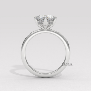 Lifestyle photo of a pear cut moissanite engagement ring in a hidden halo solitaire setting on the hand