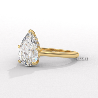 Tilted view of a pear cut moissanite engagement ring with a hidden halo and cathedral setting showing its sparkle
