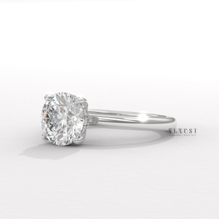 Round cut moissanite engagement ring in a solitaire setting shown on a finger
