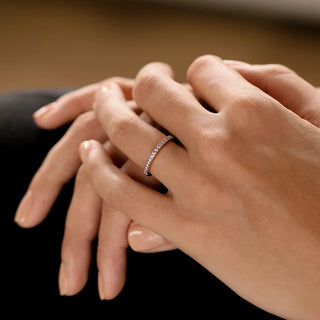 Vintage round half eternity moissanite wedding band shown on a finger