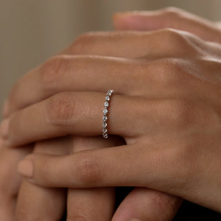 Lustrous round half eternity moissanite wedding band angled view showing its sparkle
