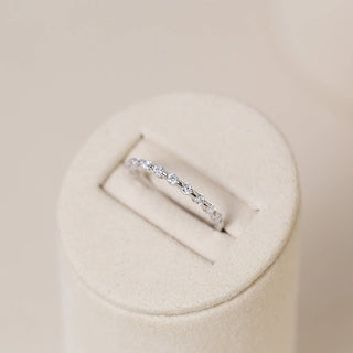 Shimmering round half eternity moissanite wedding band close up of the setting