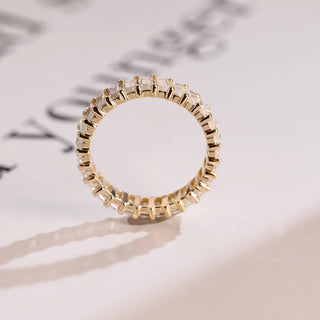 Luminous emerald full eternity moissanite wedding band shown on a finger