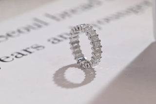 Delicate emerald full eternity moissanite wedding band angled view showing its sparkle