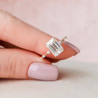 Delicate 3.0ct emerald solitaire moissanite ring shown on a finger