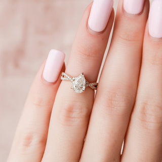 Shimmering 1.0ct pear hidden halo moissanite ring angled view showing its sparkle
