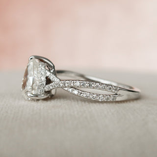 Delicate 1.0ct pear hidden halo moissanite ring shown on a finger