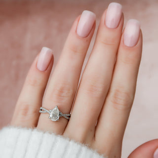 Delicate 1.0ct pear hidden halo moissanite ring angled view showing its sparkle
