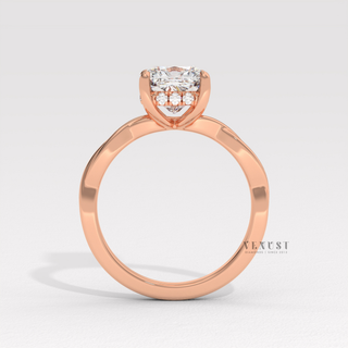 Close-up of a cushion cut moissanite engagement ring on an infinity band