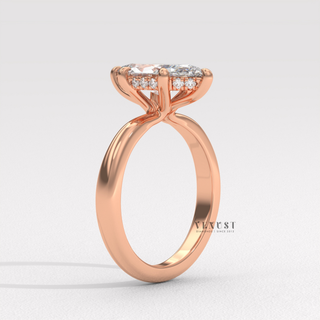 Studio shot of a marquise cut moissanite engagement ring in a hidden halo solitaire setting on a plain backdrop