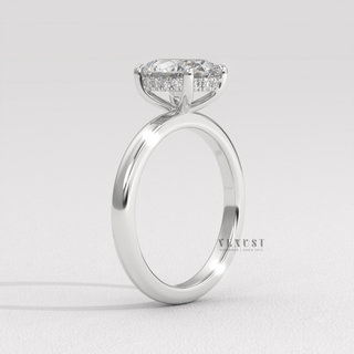 Side profile of a oval cut moissanite engagement ring in a hidden halo solitaire setting under soft light