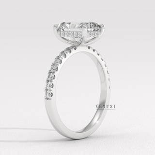 Low-angle view of a radiant cut moissanite engagement ring with a hidden halo and pave band