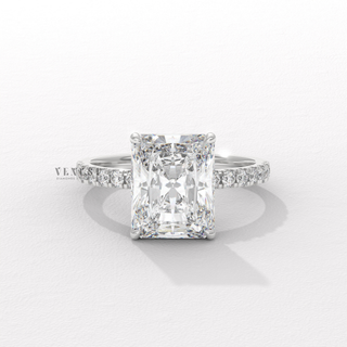 Top-down view of a radiant cut moissanite engagement ring with a hidden halo and pave band